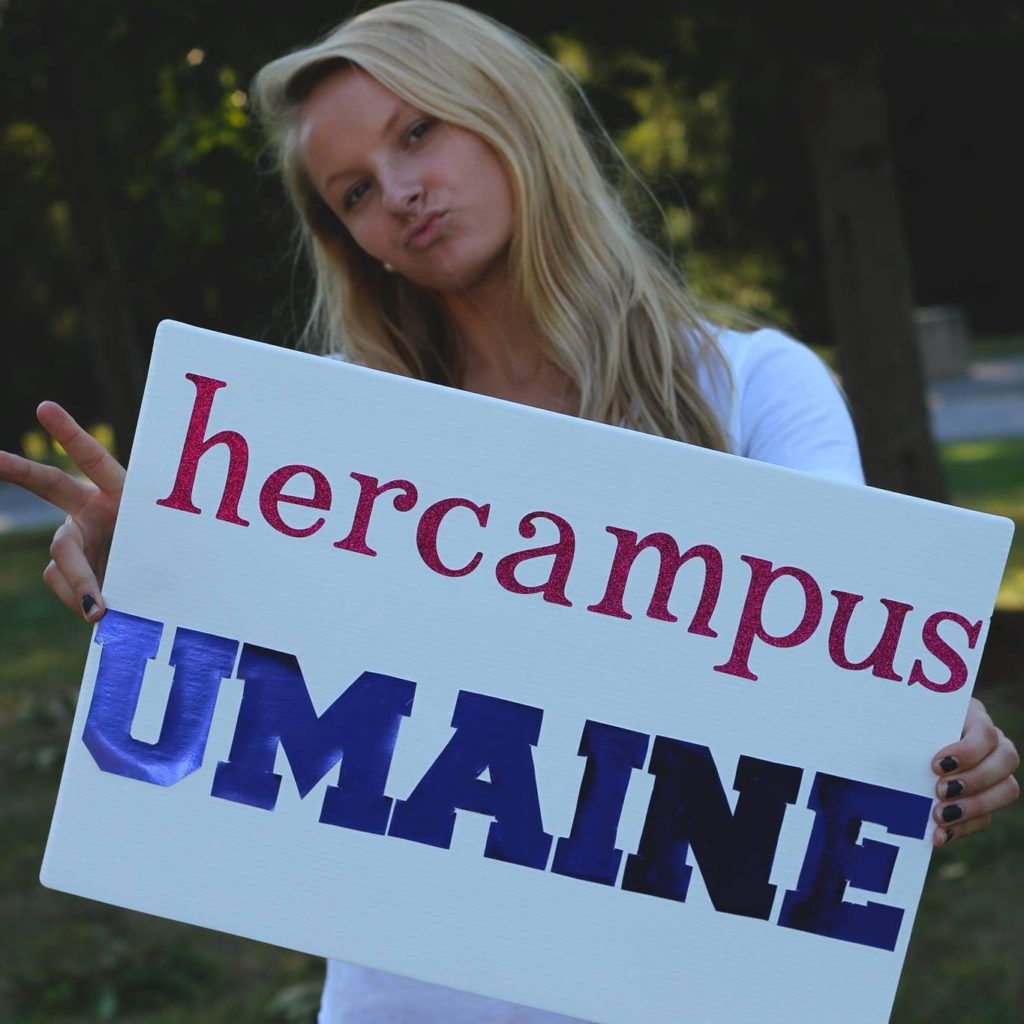 Kate holding sign that says Her Campus UMaine.